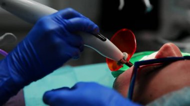 Kadın diş hekimi ve hemşirelik mühür diş bir ofis sandalye yalan hastaya ayarla.