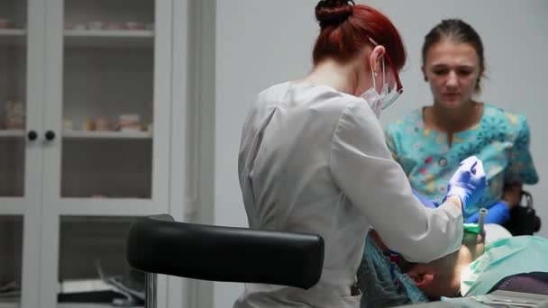 Den tandläkare och sköterska reparera en tand av en tålmodig man. Användning av bormashenko borra tänderna och ta bort karies och tätning. — Stockvideo