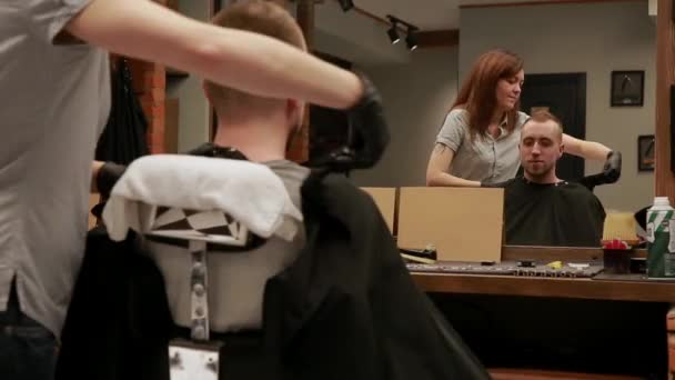 Kobiece Fryzjer gotowy do wykonania fryzury. usuwa przylądek od klienta i pokazuje mu pracę. Steadicam ujęcia. — Wideo stockowe