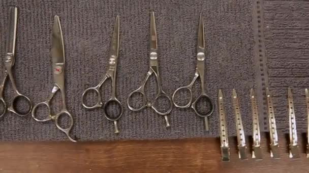 Close-up, Barbeiro ferramentas estão sobre a mesa e a mão em luvas pretas leva-los . — Vídeo de Stock
