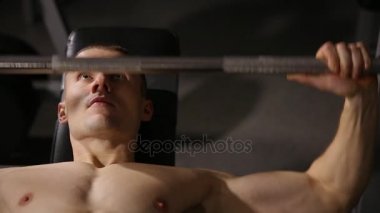 Büyük kaslar ile şişirilmiş güçlü adam artırdı bar bankta yalan yakın çekim.