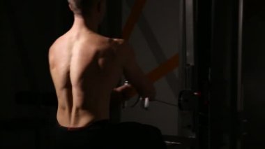 Yakın çekim, kabartma kas kürek simülatörü, holding eller geri. Alt birim oturan çek. Geri spor salonunda antrenör.