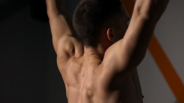Rolled man performs pull-UPS closeup in the gym. You can see all the muscles. — Stock Video