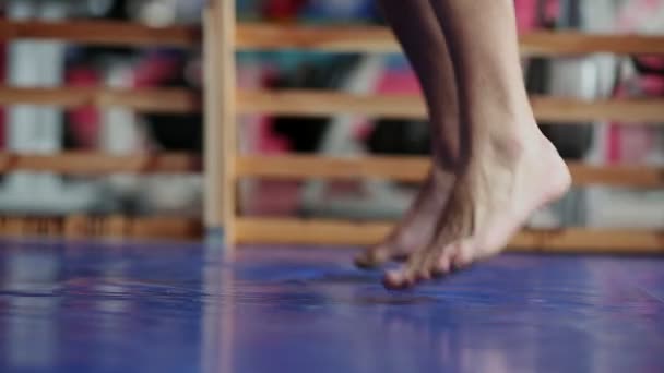 Ein Profiboxer schlägt mit nacktem Oberkörper auf den Boxsack ein. eine vertikale Kamerafahrt in Nahaufnahme. Pfanne. die Beine des Boxers. — Stockvideo