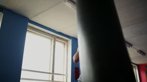 ボクシング グローブの裸胸のジムでサンドバッグで筋肉男性プロボクサー列車. — ストック動画