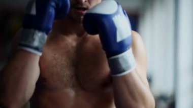 Kamera önünde boks boks eldivenli adam kapatın. Genç adam Delme close-up. Boksör performans gösteren aparkat.