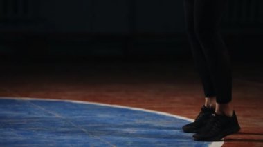 Sportif esmer boks jimnastik salonu stroke tekniği üzerinde bireysel eğitim sağlar. Yürüten grev kum torbasına siyah bir arka plan üzerinde.