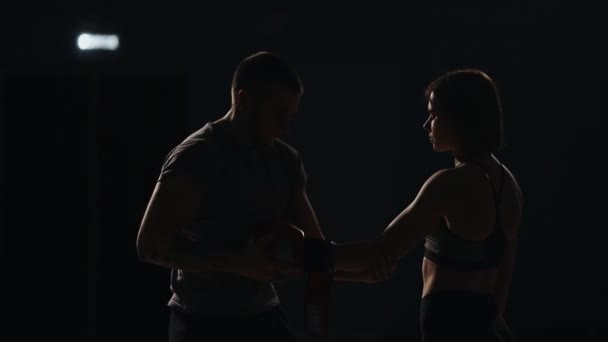 Trener nosi rękawice bokserskie z dziewczyną myśliwiec przed walką. Przygotowania do meczu. — Wideo stockowe