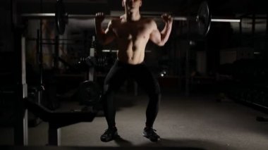 Yakışıklı kaslı adam egzersiz spor salonunda squats.