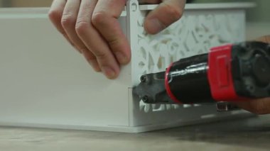 Profesyonel çalışan erkek elinde Close-Up için çivi çivi silah zımba kullanarak hediye kutusu toplar.