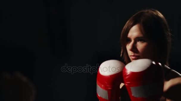 Muscular fitness girl training with his instructor to carry out strikes on the feet in Boxing gloves. The lesson of self-defense. A Boxing workout. Close-up — Stock Video
