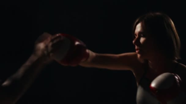 Entrenamiento de chica fitness muscular con su instructor para llevar a cabo huelgas en los pies en guantes de boxeo. La lección de la autodefensa. Un entrenamiento de boxeo. Primer plano — Vídeos de Stock