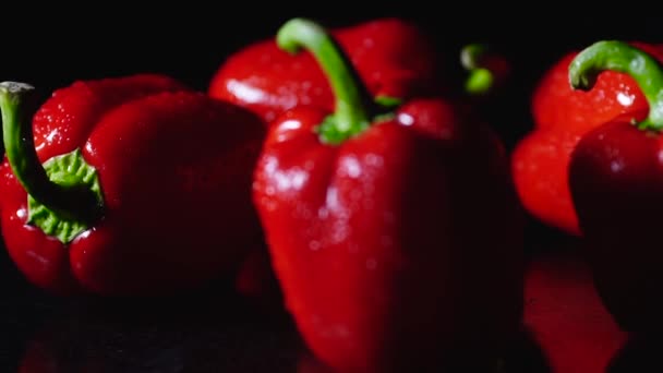 Verse rode pepers vers weggespoeld druppels stroom op tafel. Closeup draaien op zwarte achtergrond. — Stockvideo