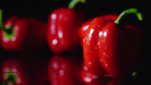 En primer plano el pimiento rojo grueso, y el enfoque se mueve suavemente en el fondo, donde se encuentran algunos pimientos más . — Vídeos de Stock