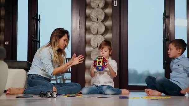 Toplama çocuk Tasarımcısı ülke evi birlikte vakit katta oturan iki çocuk mutlu anne. Panoramik pencerelere ile oturma odası. — Stok video