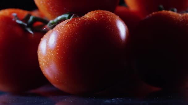 Una gran cantidad de tomate fresco maduro acostado en una mesa de vidrio negro y gira alrededor de su eje. Primer plano verduras frescas . — Vídeos de Stock