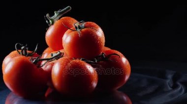 Siyah bir yalan olgun taze domates çok tablo cam ve kendi ekseni etrafında döner. Yakın çekim taze sebze.