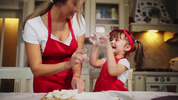 Lycklig familj i kök mamma och dotter i köket spelar med mjöl för att ha kul och forma biffarna i köket i samma röda förkläden. stedicam — Stockvideo