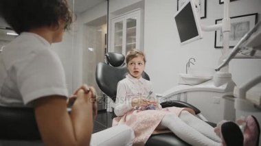 Çocuk diş hekimi ofisimde küçük kız ile bir Danışma yürütmektedir. Gelecekteki tedavi tartışırken bir kız doktor konuşur.