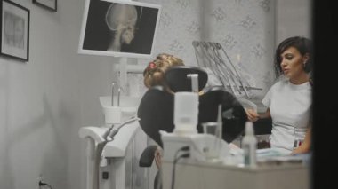 Çocuk diş hekimi ofisimde küçük kız ile bir Danışma yürütmektedir. Gelecekteki tedavi tartışırken bir kız doktor konuşur.