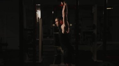 Kaslı adam spor salonunda ağırlık egzersizleri yapıyor. Kettlebell parçalarının.
