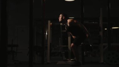 Kaslı adam spor salonunda ağırlık egzersizleri yapıyor. Kettlebell parçalarının.