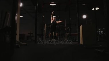 Kaslı adam spor salonunda ağırlık egzersizleri yapıyor. Kettlebell parçalarının.