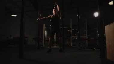 Kaslı adam spor salonunda ağırlık egzersizleri yapıyor. Kettlebell parçalarının.