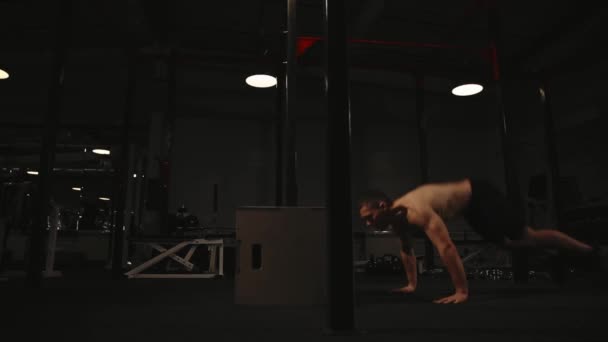 Muskulöser Mann ohne Hemd führt die Burpee-Übung aus und springt auf eine Holzkiste — Stockvideo