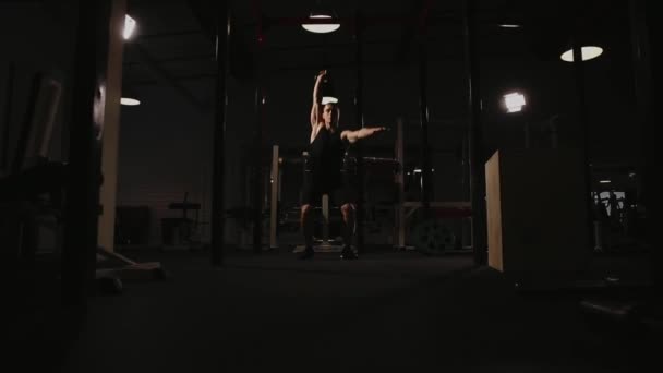 Uomo muscolare che fa esercizi con pesi in palestra. Il presepe del kettlebell . — Video Stock