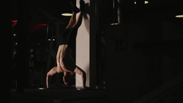 Gespierde man die op handen in de sportschool door de muur voert push-Ups. — Stockvideo