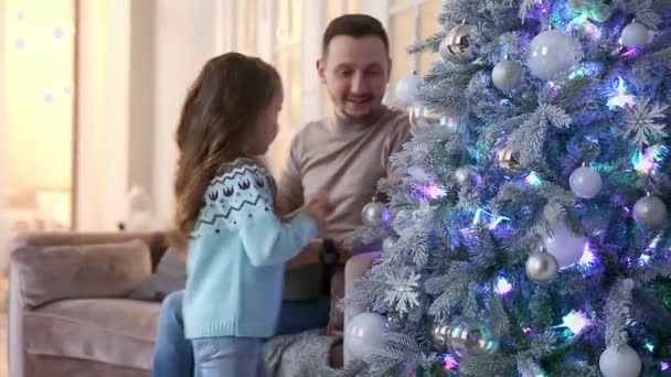 Vater und Tochter schmücken den Weihnachtsbaum. — Stockvideo