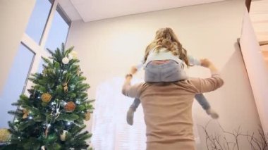 Boyunda, Papa'nın ben oturan kız uçak oynayan, gülen ve sarılma baba döner kızı. Noel mutlu aile.