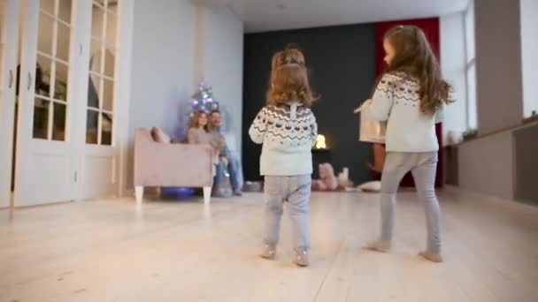 Twee zussen in de kerst draaien om giften te geven aan hun ouders. — Stockvideo