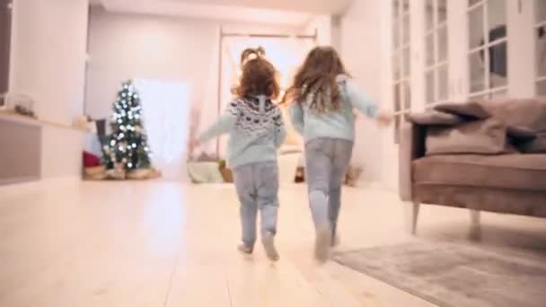 Dos hermanas en la carrera de Navidad para dar regalos a sus padres . — Vídeos de Stock