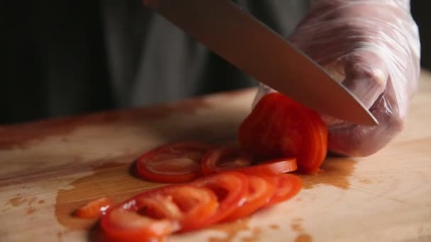 男性手特写把熟西红柿的刀和切片放在砧板上. — 图库视频影像