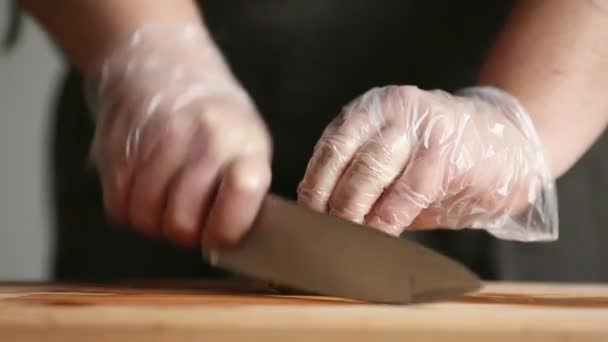 Un chef profesional corta un pepino en guantes . — Vídeos de Stock