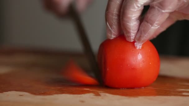 Erkek el yakın çekim bıçak ve olgun domates dilimleri bir kesme tahtası alır. — Stok video