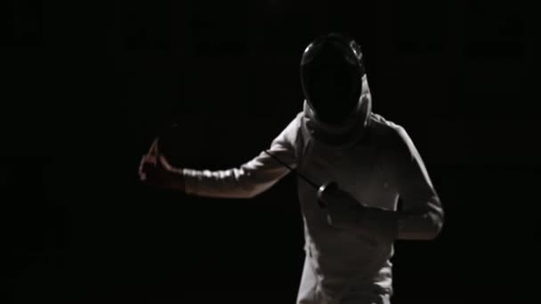 A man dressed for fencing and mask hand adjusts his rapier. Focus on the sword. — Stock Video