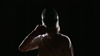 Eskrim için giyinmiş bir adam bir maske takıyor ve bir rapier hazırlanıyor. Yakın çekim. Fikir tartışması başlatmak için pozisyon