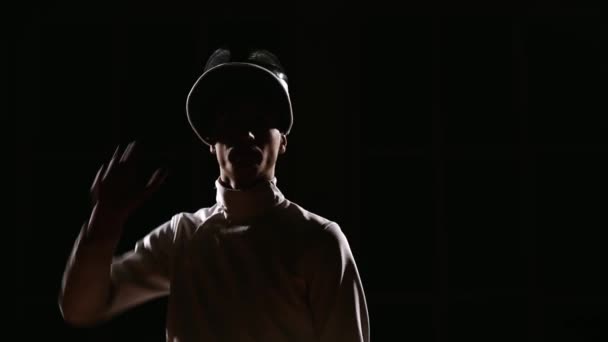 A man dressed for fencing wears a mask and is preparing a rapier. Close-up. Portrait — Stock Video