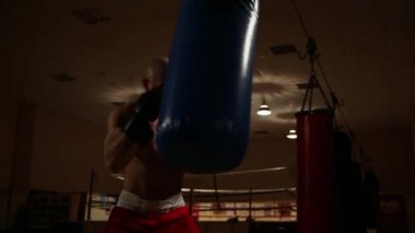 Profesyonel bir boksör yumruk çalışmak için bir boksör armut eğitimi yürütmektedir.