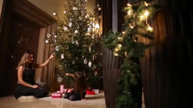 Anne ve kızı cam Noel ağaçları ile Noel ağacı süslemeleri.