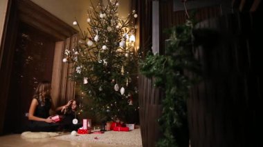 Anne ve kızı Noel ağacı kadar elbise. Kız Noel oyuncaklar seçer