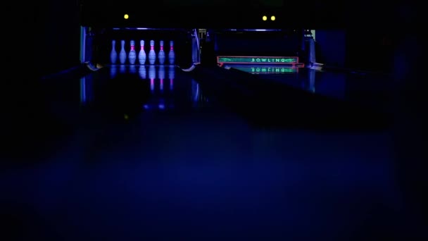 Im Kegelclub wirft der Spieler eine Bowlingkugel auf die Stifte. — Stockvideo