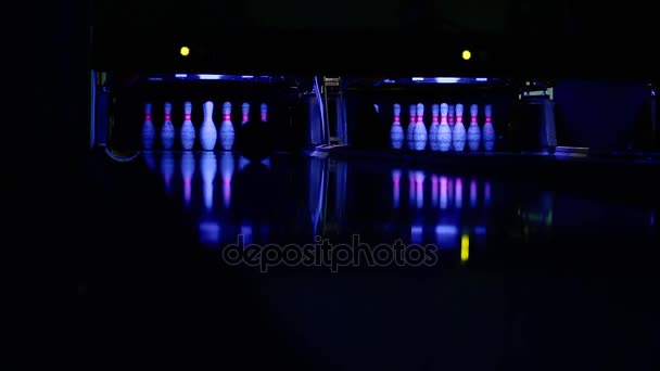 De bowling bal rolt langs het pad in de richting van de pinnen. breekt alle pinnen behalve een. — Stockvideo