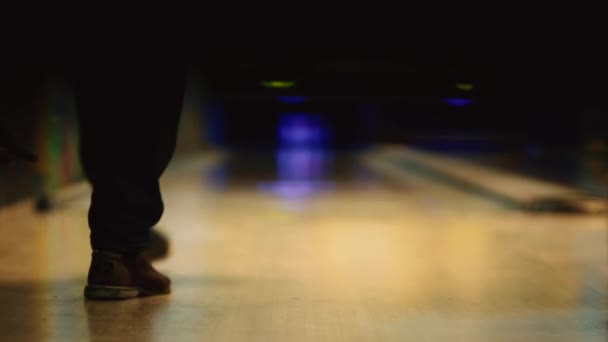 In de game club voor bowling gooit de speler een bowlingbal die beneden kegelen klopt. Vloeiende beweging van de focus, vanaf de voorkant naar de achterkant. — Stockvideo