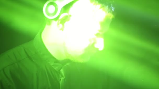 Close-up de um DJ coloca fones de ouvido em sua cabeça e toca música usando o painel de música. O guindaste move a câmera verticalmente . — Vídeo de Stock