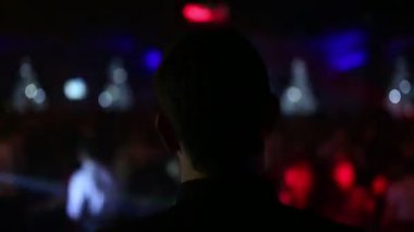 Bir Dj baş görünümü arkadan ve judi bir partide dans bir bulanık arka plan bokeh Close-Up