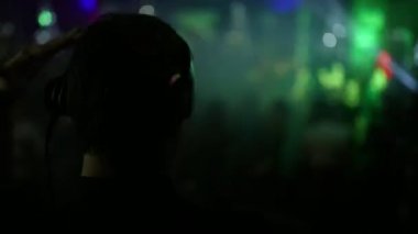 Arkadan Görünüm. Arka ve ön planda, Dj kulaklık dans eden insanlar bulanık.